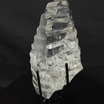 Side view of Lemurian Quartz Display Piece - High Quality Semi Polished Faceted Lemurian With Stand showing natural crystal details